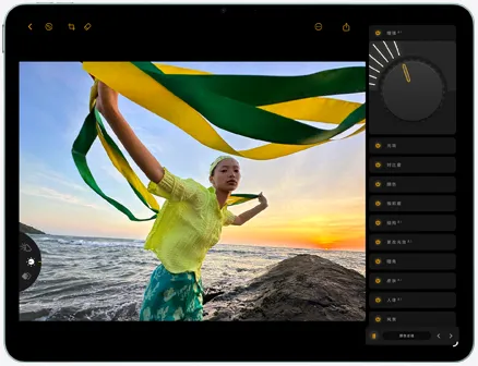 iPad Air 的正面外观，屏幕显示正在编辑的人物照，画中人手持绿色和黄色的飘带站在海边，背后是落日余晖，编辑工具位于屏幕右侧。