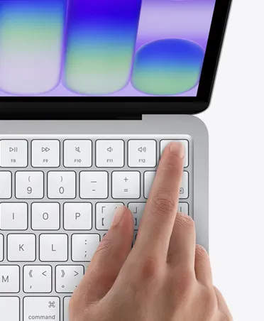 银色 MacBook Neo，用户将手指放在键盘右上角的触控 ID 传感器上。