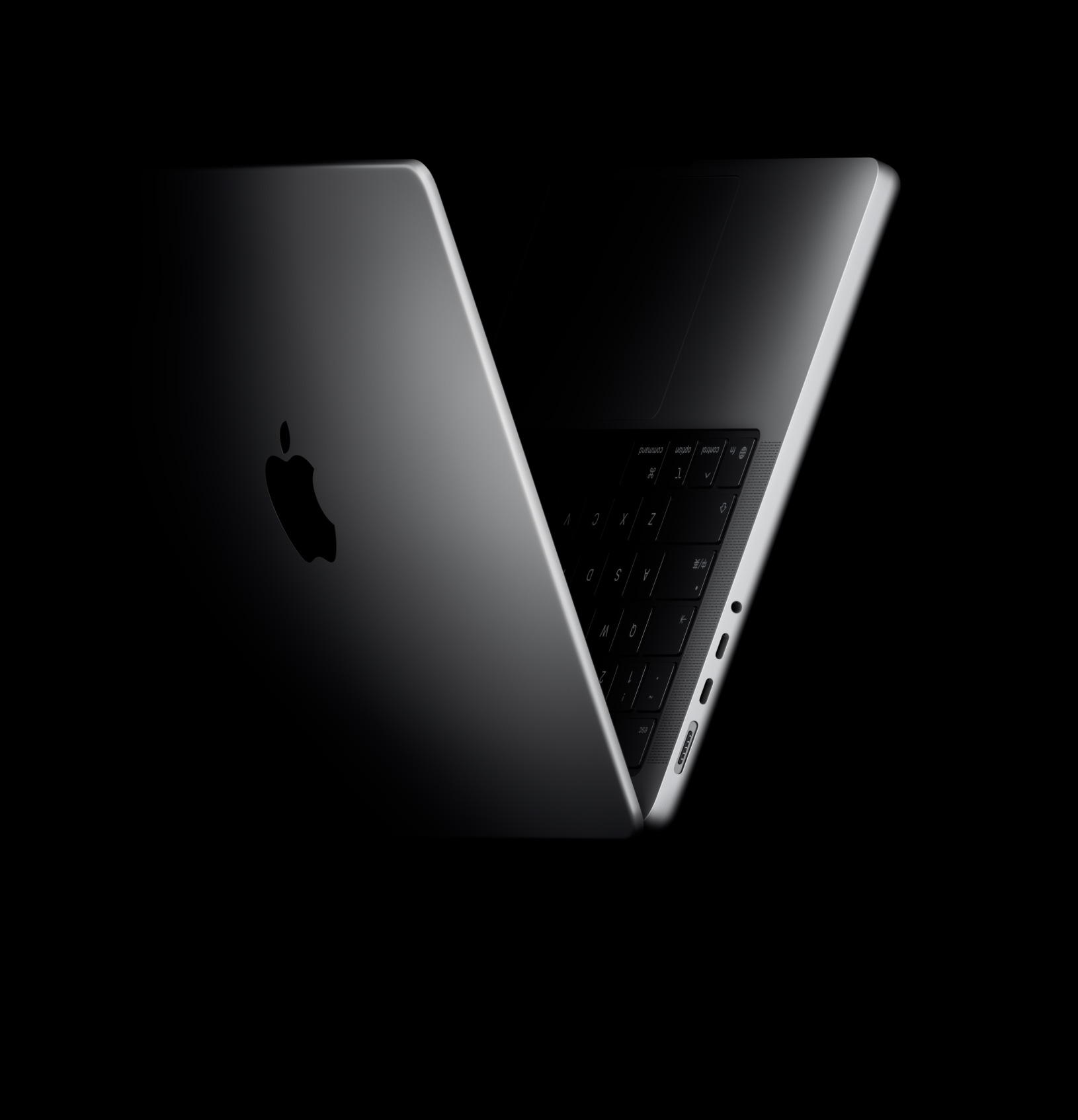 一台 MacBook Pro 摆成半开半合的姿态，侧面视角呈 V 字形，即罗马数字五，意指 M5 芯片系列。