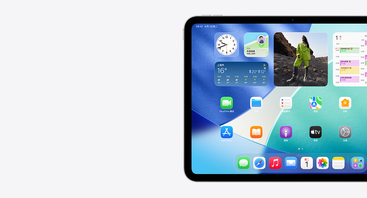 横屏放置的 iPad，仅展示屏幕左侧，主屏幕具有叠放的小组件，包括呈现 Liquid Glass 效果的半透明时钟、查找 app、天气小组件、两排较小的 app 以及程序坞。