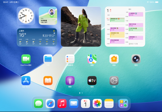 三款 iPad 机型横屏放置，中间的机型位于另外两款前方，Apple Pencil 以磁力吸附在中间机型的顶部；中间屏幕显示主屏幕，展示具有 Liquid Glass 效果的彩色 app 图标；左侧屏幕展示预览 app；右侧屏幕展示主屏幕，多个文件以扇状形式从程序坞中展开。