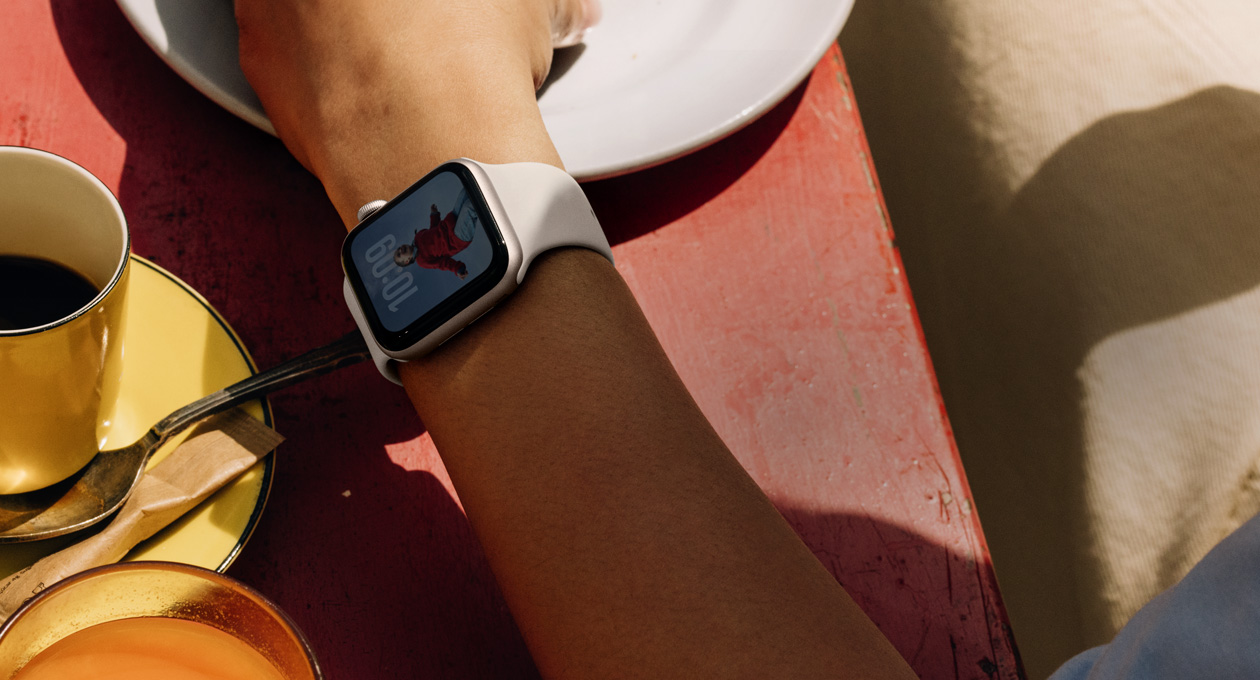 Apple Watch SE 3，展示星光色铝金属表壳、全天候显示屏、照片表盘，搭配星光色运动型表带。