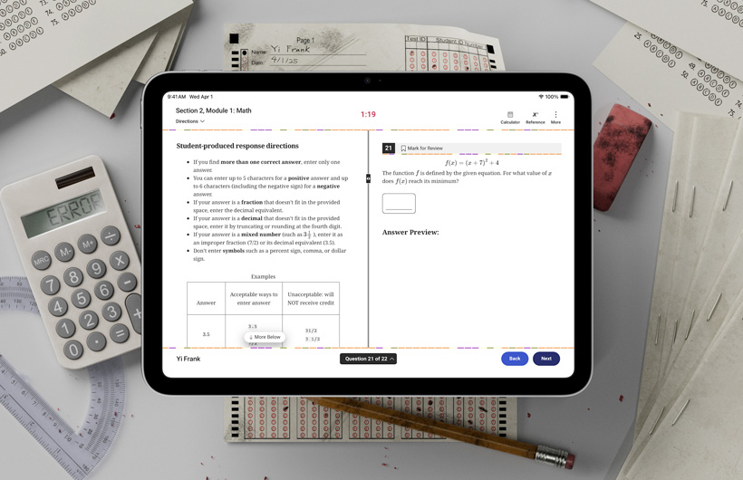 一部 iPad 放在书桌上，周围是纸质答题卡和学习用品。屏幕上显示关于完成标准化考试数学部分的说明。