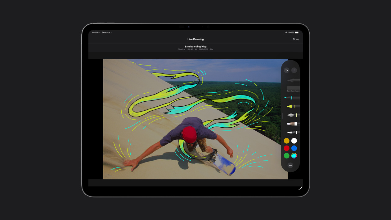 13 英寸 iPad Pro 屏幕画面显示滑沙者在沙丘上滑行，身体周围有黄色和蓝色的动态线条效果，以此展示实时绘制功能。