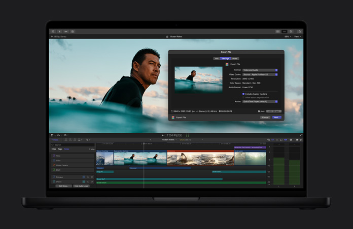 16 英寸 MacBook Pro 屏幕显示冲浪者在海中等待浪头的画面，文件导出窗口处于打开状态，屏幕底部显示视频片段时间线。