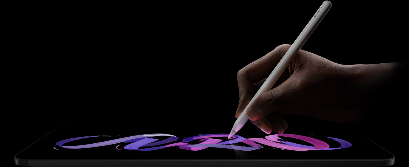 深空黑色 iPad Pro 横屏放置，正面外观展示侧面机身；一只手握着白色 Apple Pencil Pro 在屏幕上绘制紫色和粉色的抽象图案。
