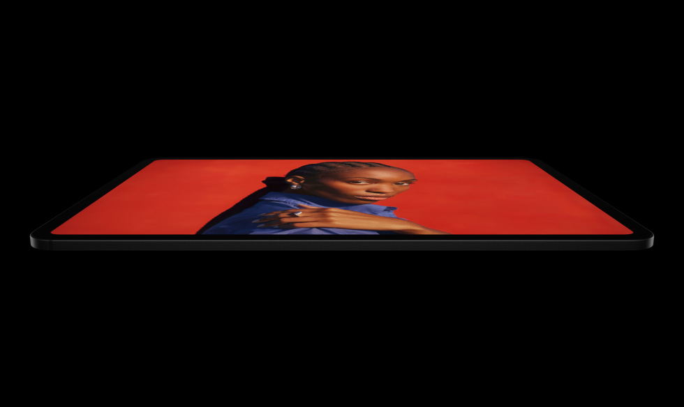 横屏放置的深空黑色 iPad Pro 侧面外观，展示圆角设计、黑色显示屏边框。屏幕显示绚丽的红色画面：一个人身穿蓝色衬衫、单手搭肩。