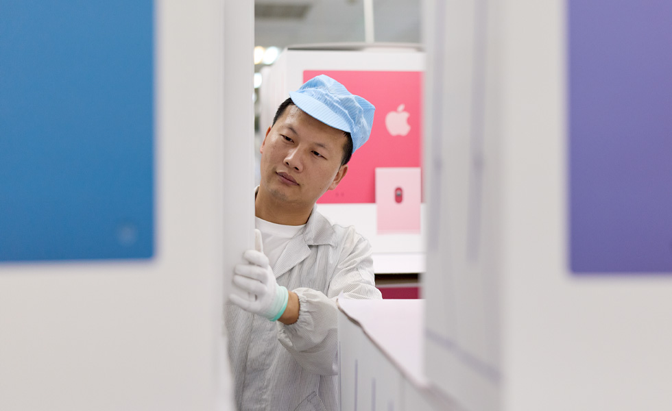 制造厂中身着防护服的工人正在检查设备